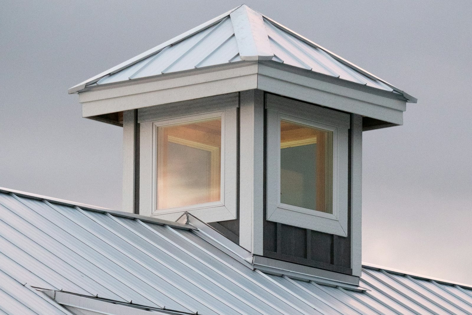 Standing seam metal roof running up to a dormer window