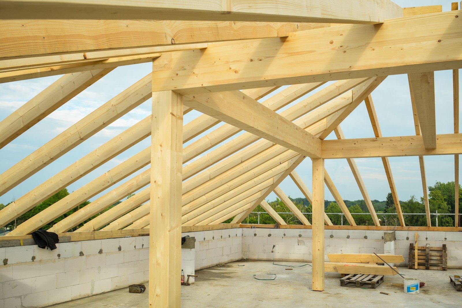 Post frame building under construction with trusses set on the posts
