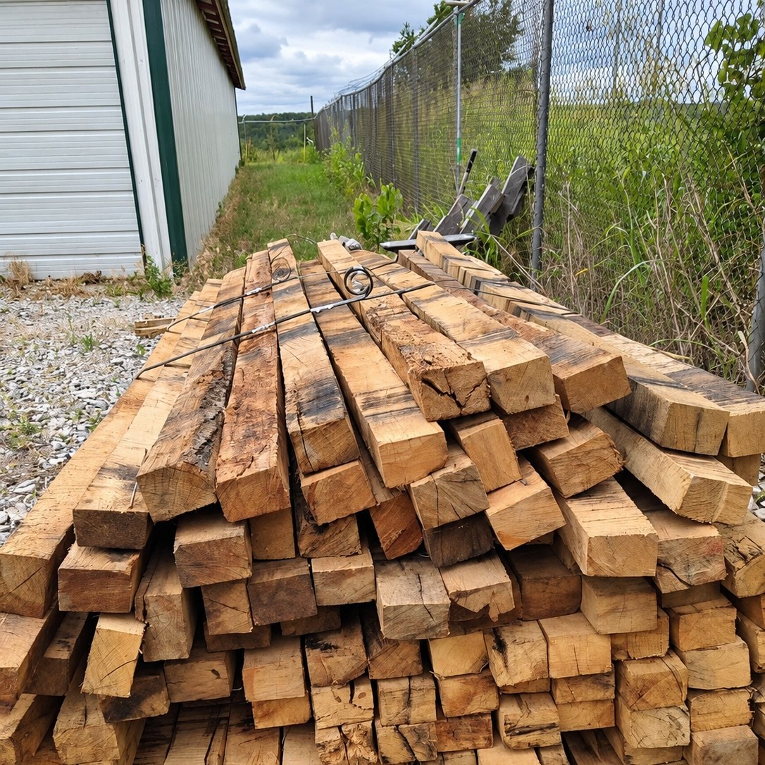 Heavy sawn timbers banded and stacked beside the truss shop