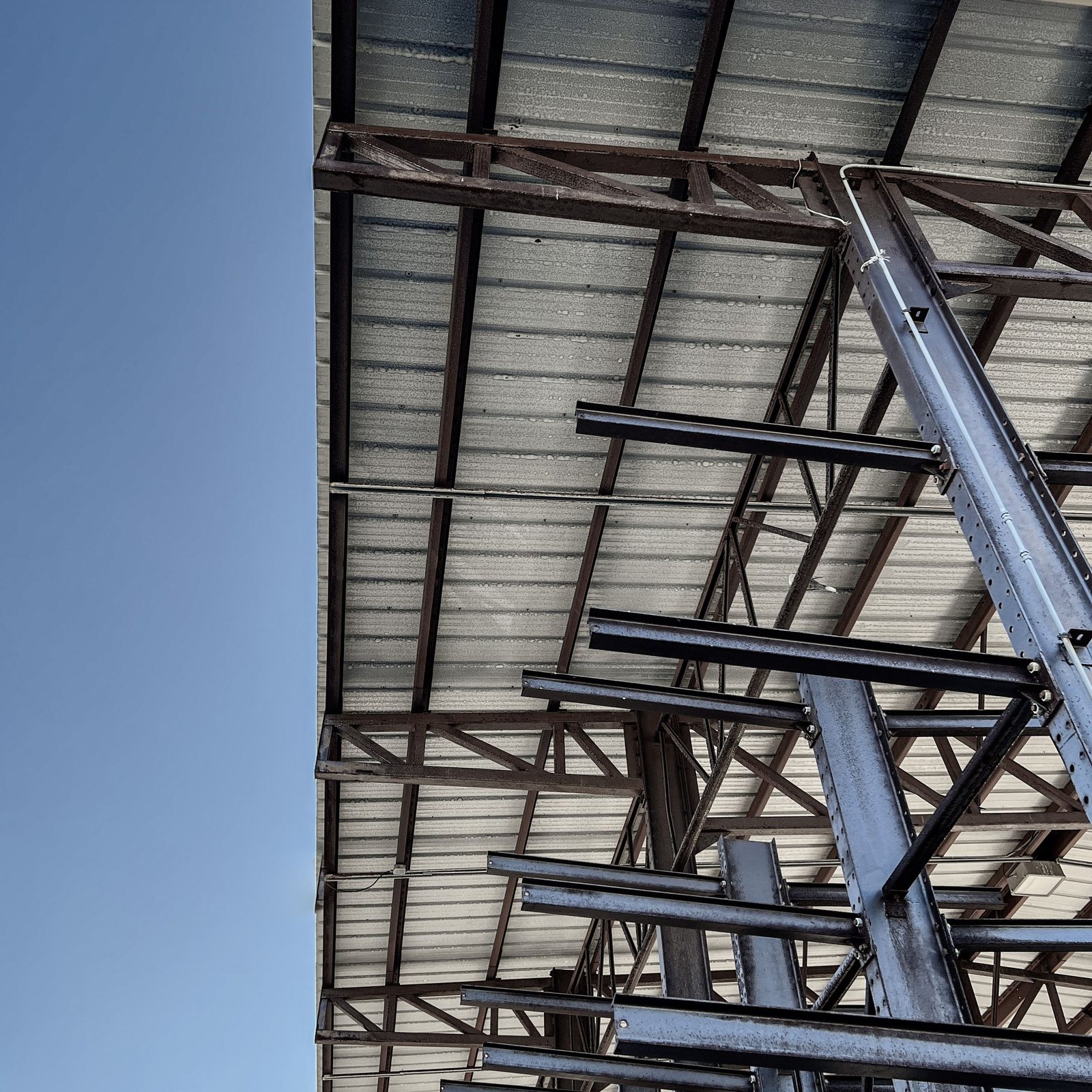 Steel building frame going up against a clear sky